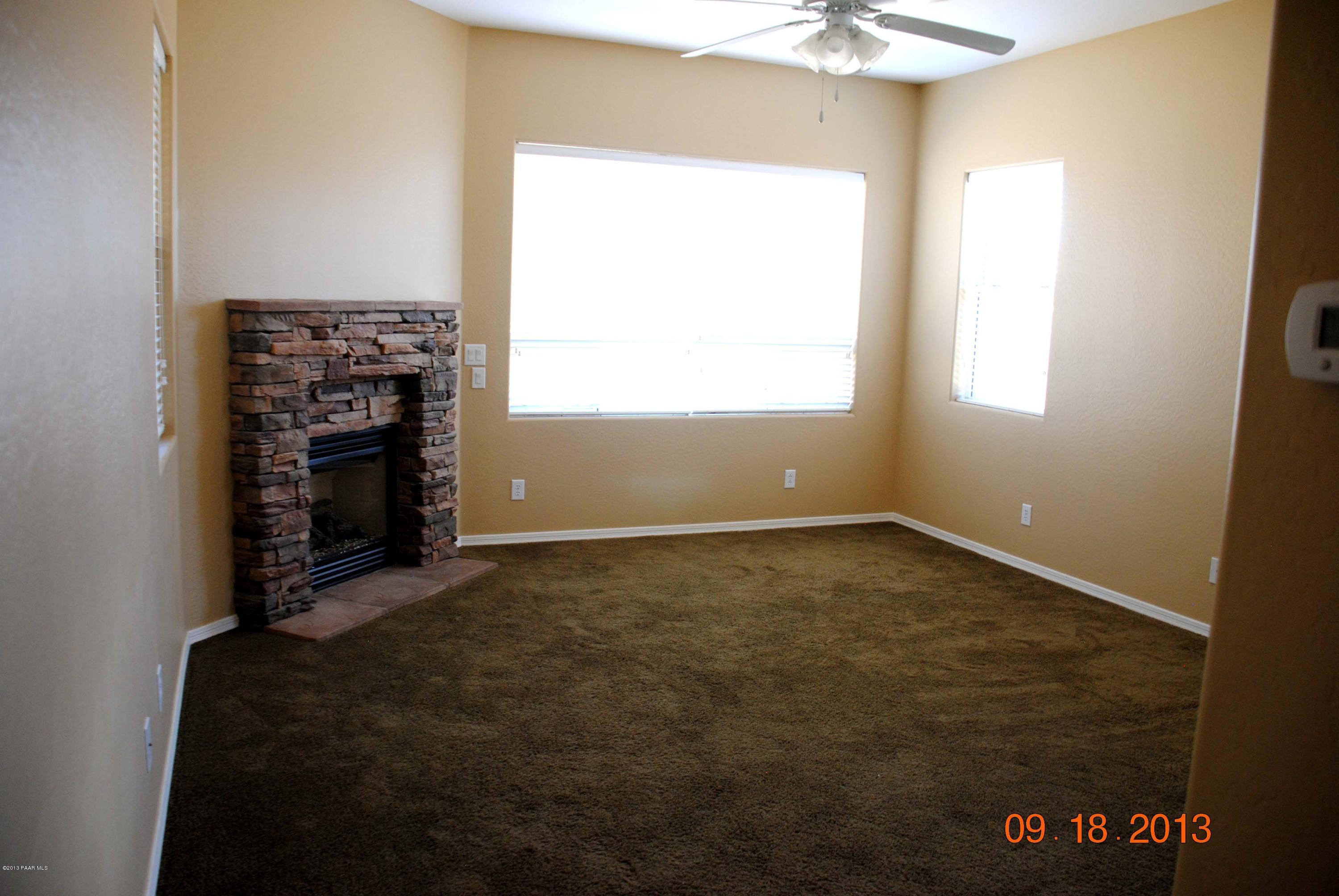 7906 East Mesteno Road Prescott Valley, AZ 86315 - Photo 10 of 24 an empty room with a fireplace and a window