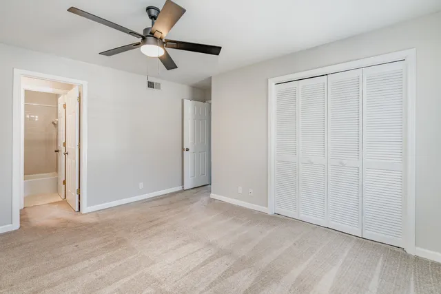 a view of an empty room and chandelier fan