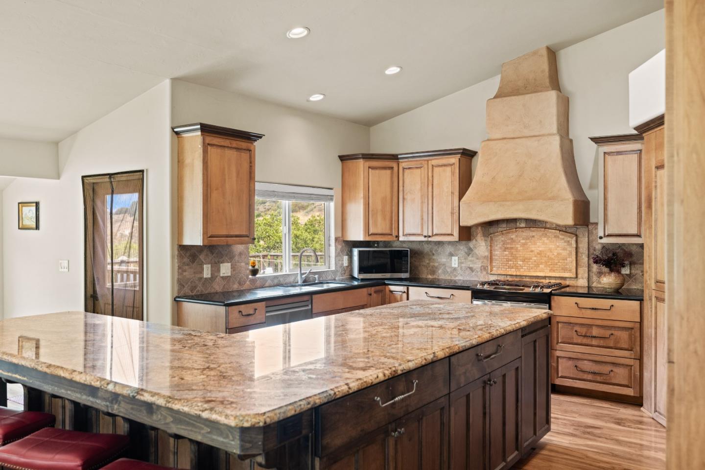 a kitchen with granite countertop a stove and cabinets