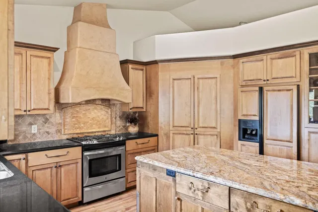 a kitchen with stainless steel appliances granite countertop a stove and a refrigerator
