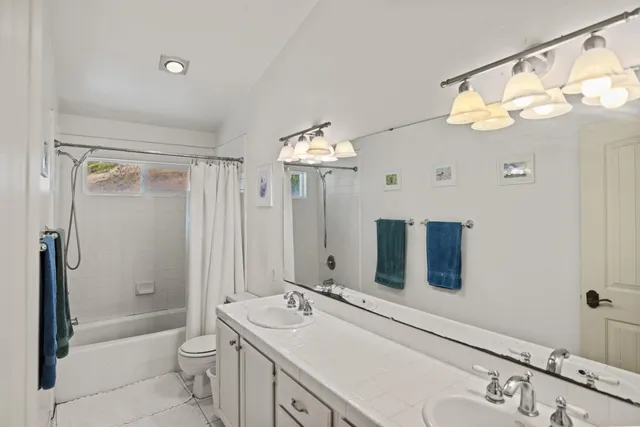 a bathroom with a double vanity sink mirror and toilet