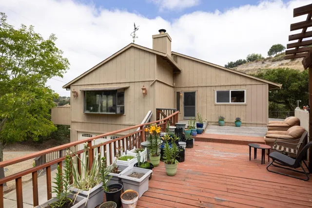 a view of a house with wooden deck and furniture
