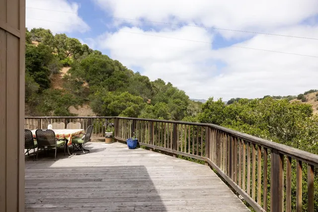 a view of a balcony with wooden floor and fence