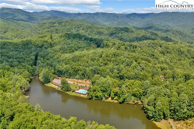 a view of a pool with lawn chairs under an umbrella