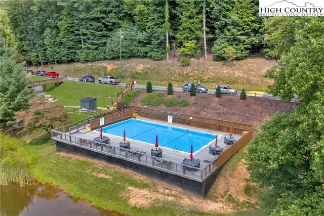 a aerial view of a house with swimming pool and large trees