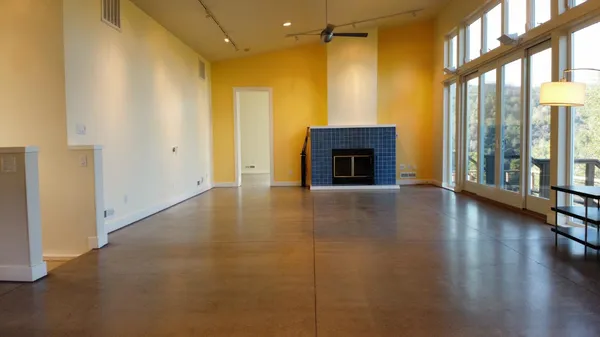 a view of an empty room with glass door and a window