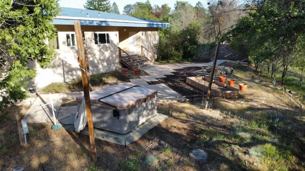 a backyard of a house with a yard fire pit and large tree