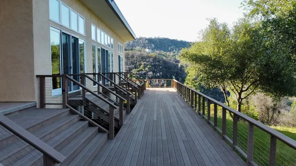 a view of balcony with wooden floor and fence