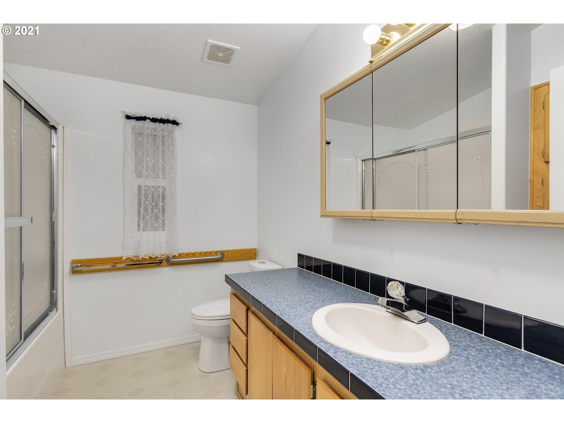 212 Northeast 253rd Street Ridgefield, WA 98642 - Photo 13 of 28 a bathroom with a granite countertop sink toilet and mirror