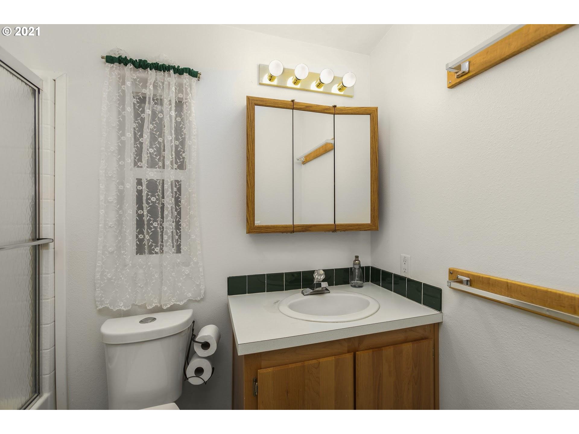 212 Northeast 253rd Street Ridgefield, WA 98642 - Photo 16 of 28 a bathroom with a sink a light fixture and a toilet