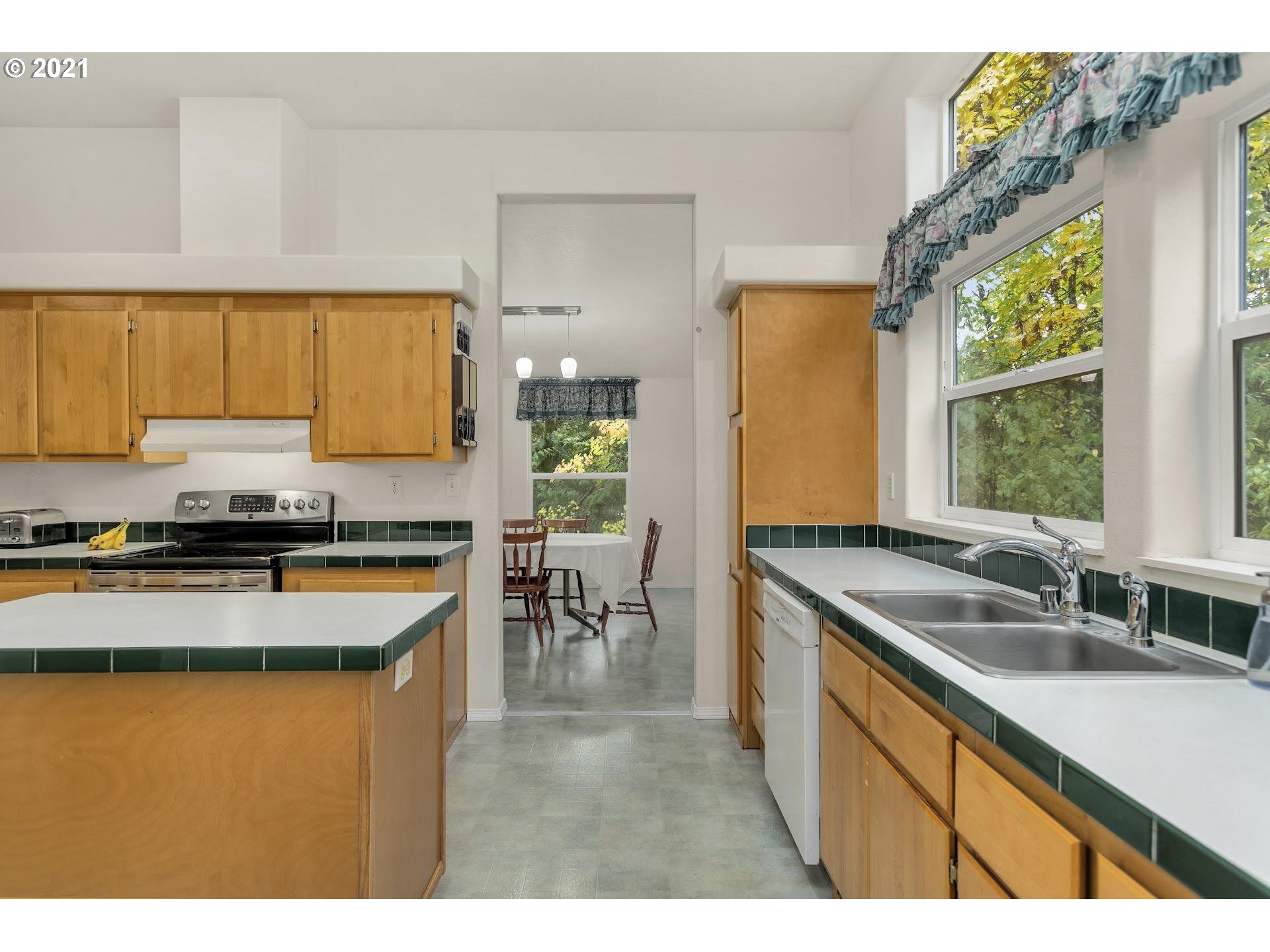 212 Northeast 253rd Street Ridgefield, WA 98642 - Photo 5 of 28 a kitchen with stainless steel appliances granite countertop sink stove top oven and cabinets