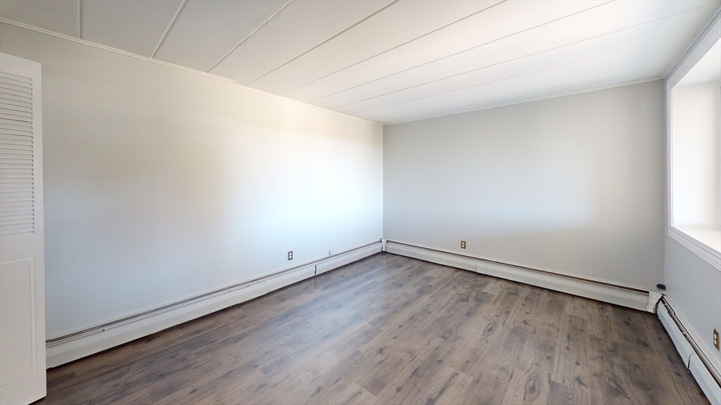 22 Nelson Drive, Unit 3E Randolph, MA 02368 - Photo 4 of 6 an empty room with wooden floor