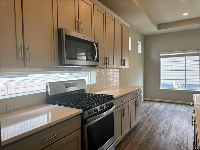 a kitchen with stainless steel appliances granite countertop a stove and a microwave