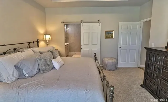 a bedroom with a bed and a refrigerator