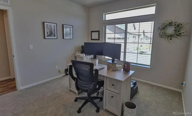 a view of a workspace with furniture and a window