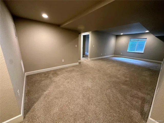 an empty room with windows and fireplace