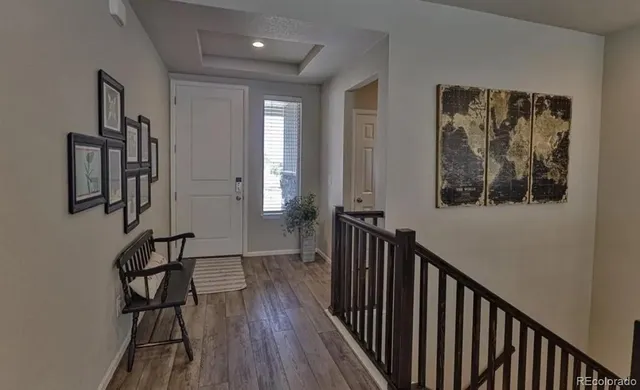 a view of a hallway with wooden floor and closet