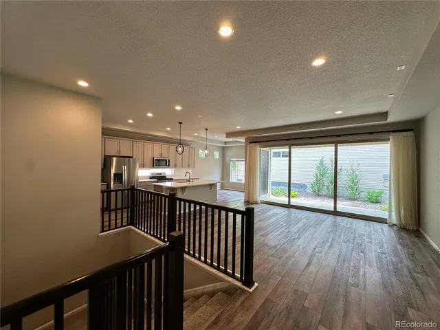 a view of a kitchen with wooden floor and iron stairs