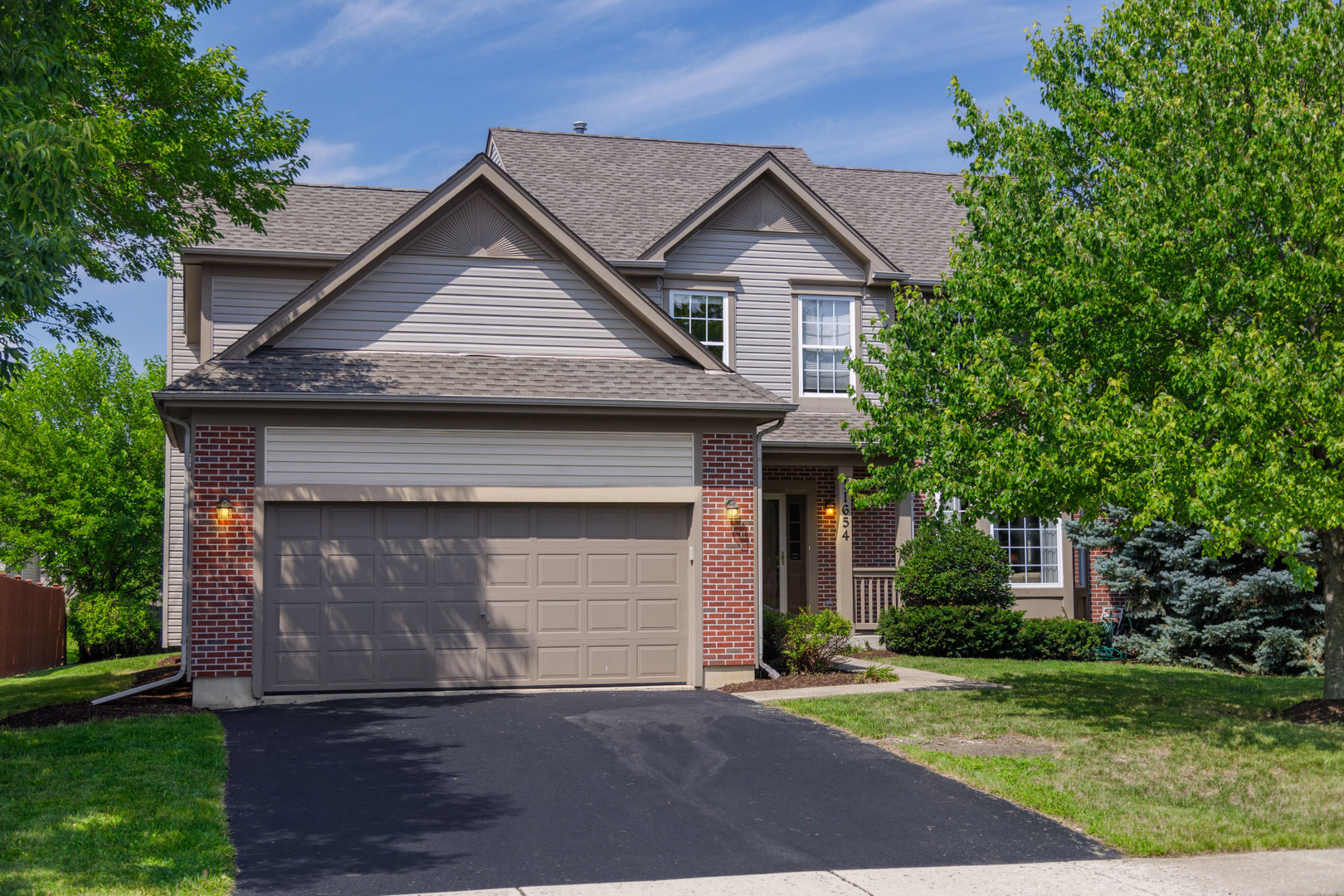 11654 Olympic Drive Plainfield, IL 60585 - Photo 1 of 25 a front view of a house with a yard and garage
