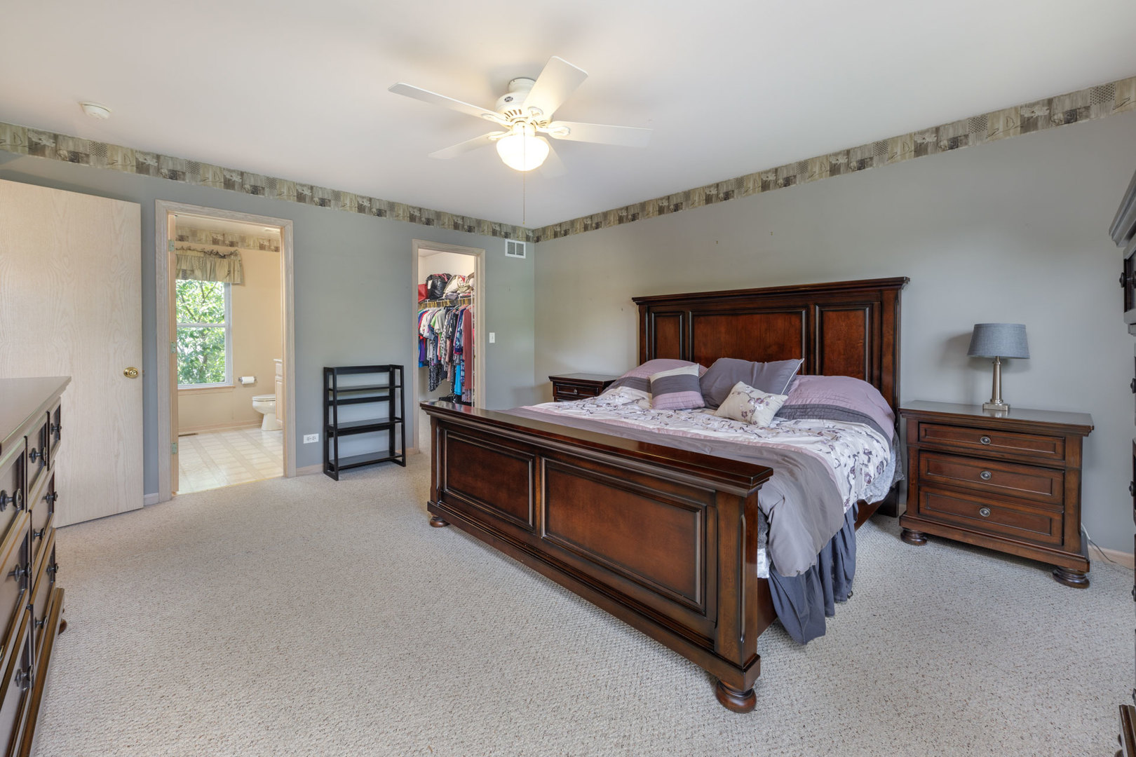 11654 Olympic Drive Plainfield, IL 60585 - Photo 15 of 25 a bed room with a bed and a chandelier