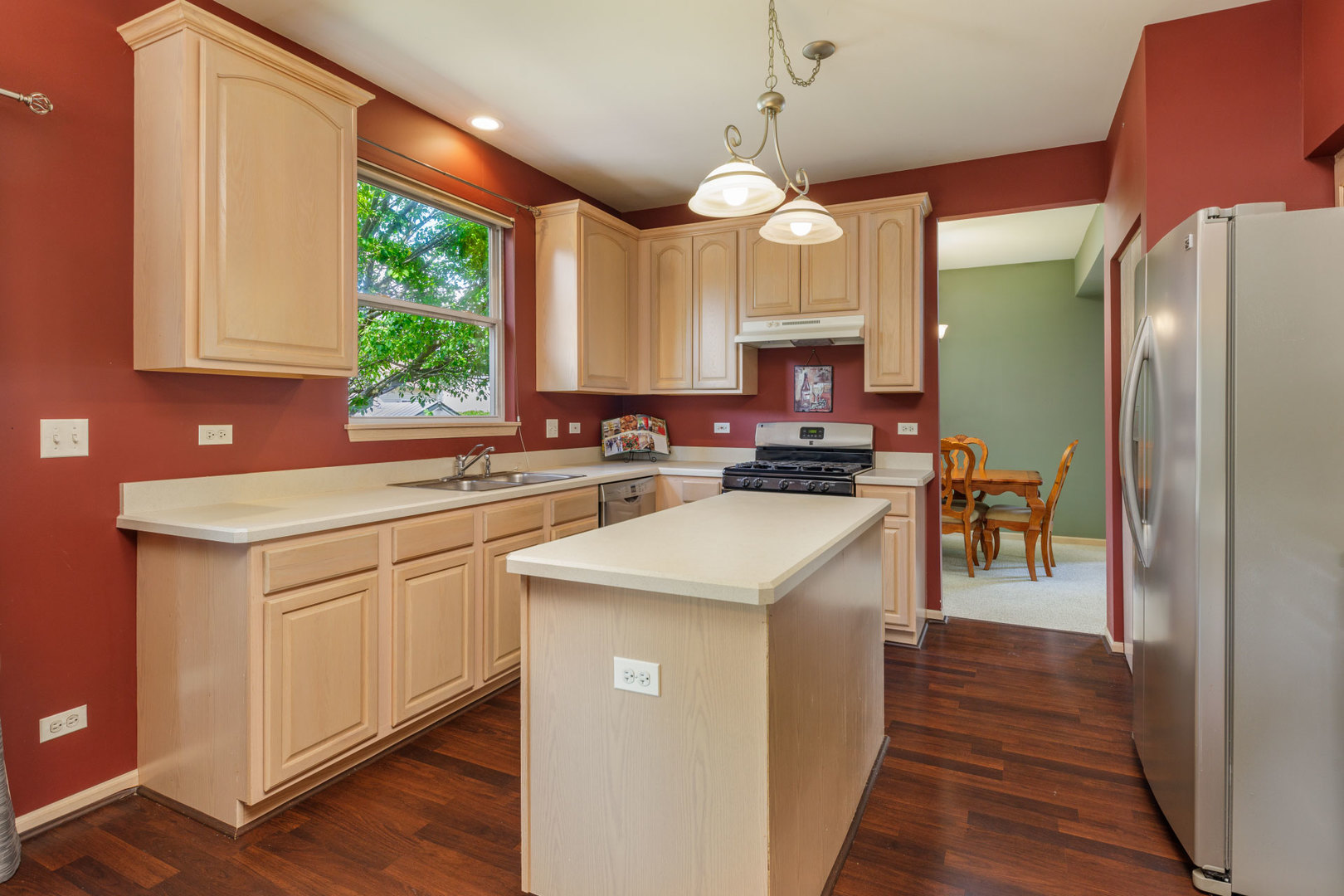 11654 Olympic Drive Plainfield, IL 60585 - Photo 5 of 25 a kitchen that has a lot of cabinets in it and wooden floors