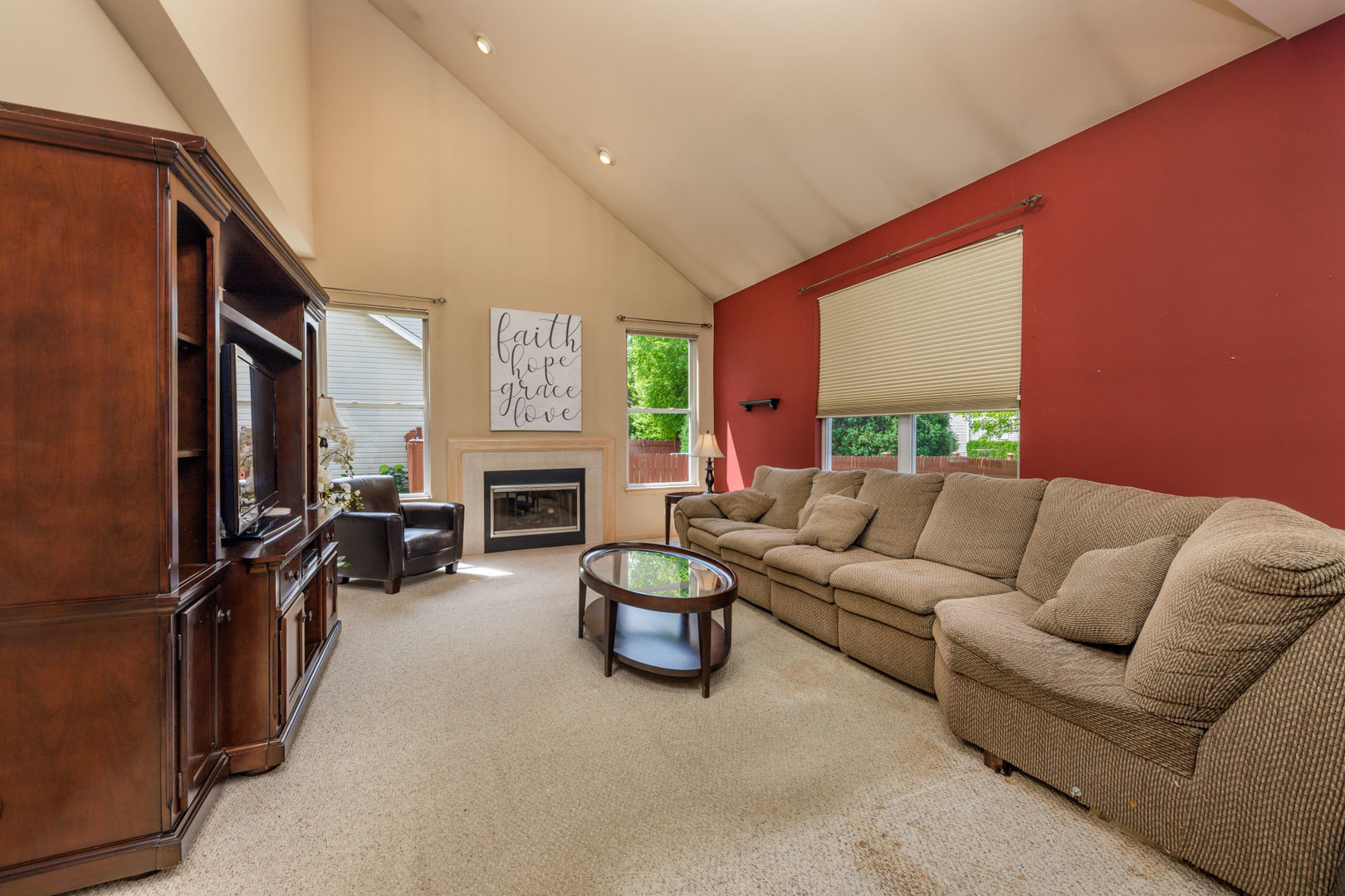 11654 Olympic Drive Plainfield, IL 60585 - Photo 8 of 25 a living room with furniture a fireplace and a flat screen tv