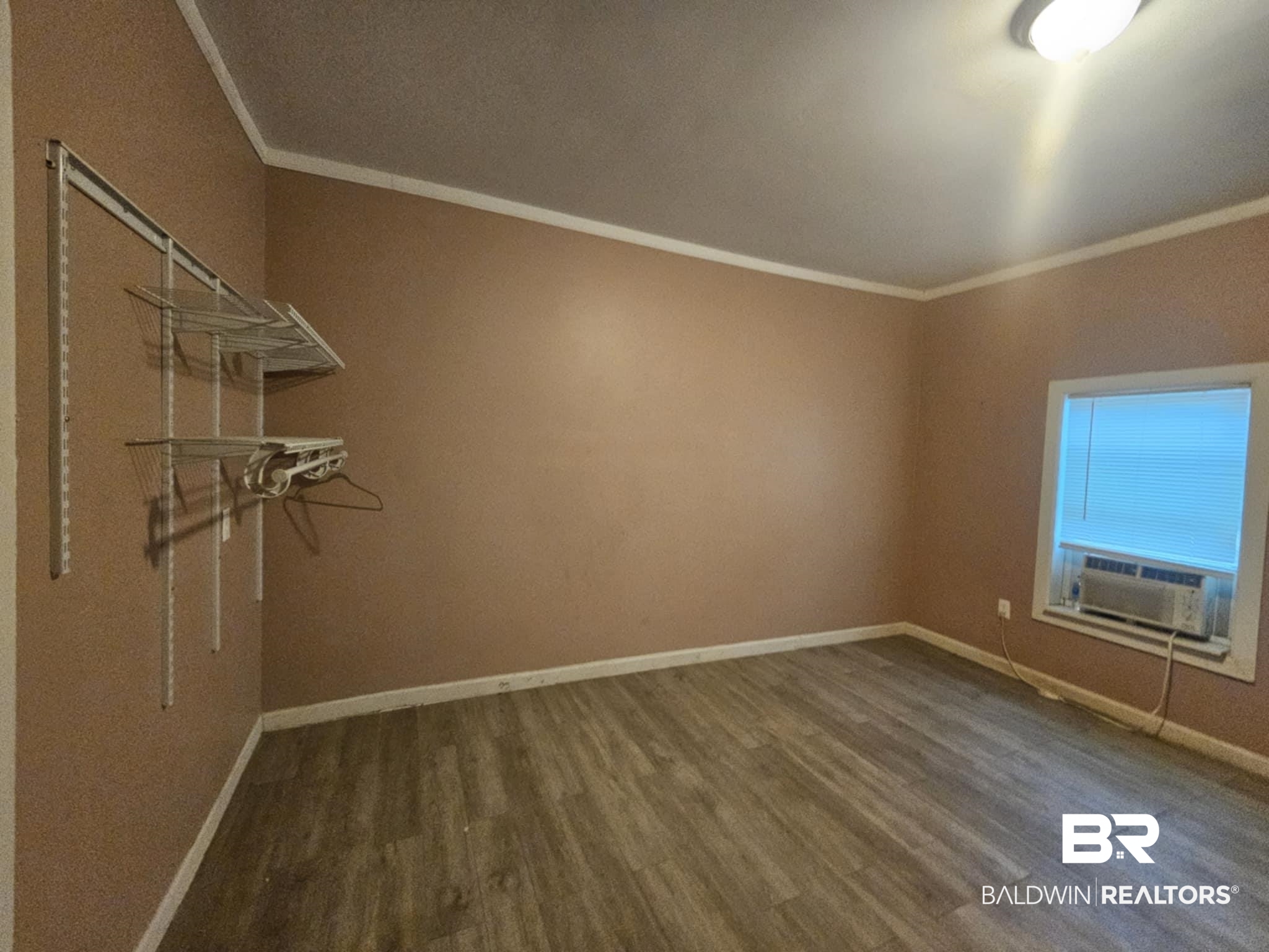 31398 Brady Road Robertsdale, AL 36567 - Photo 12 of 17 Empty room with ornamental molding, cooling unit, baseboards, and wood finished floors
