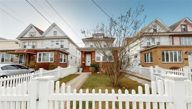 a front view of a residential apartment building with a yard