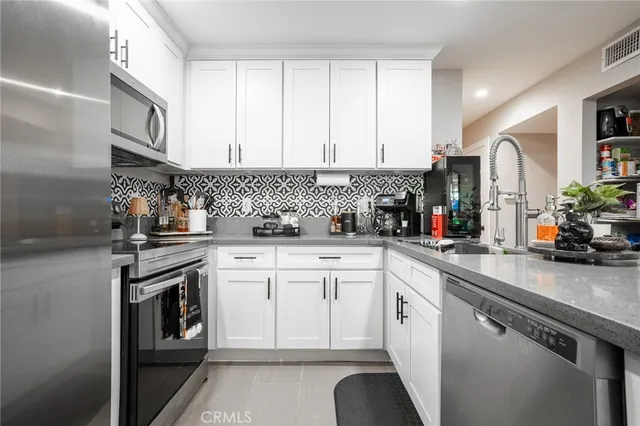 a kitchen with white cabinets and white appliances