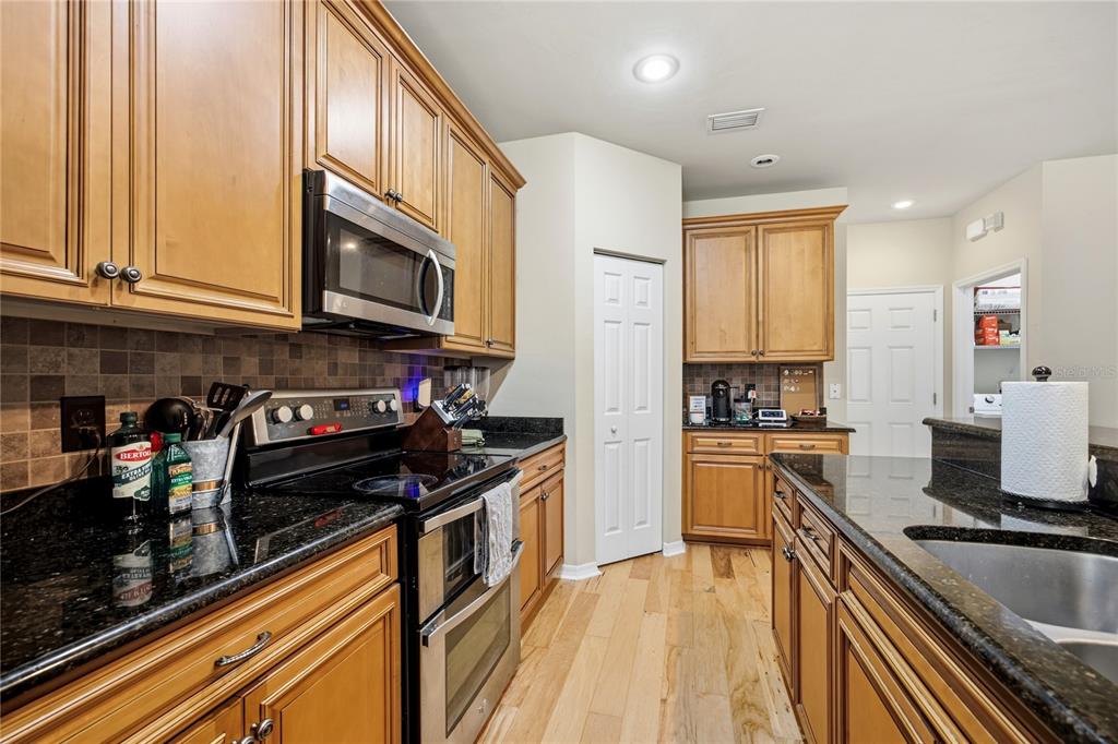 7550 Southwest 81st Way Gainesville, FL 32608 - Photo 12 of 31 a kitchen with stainless steel appliances granite countertop a stove and cabinets