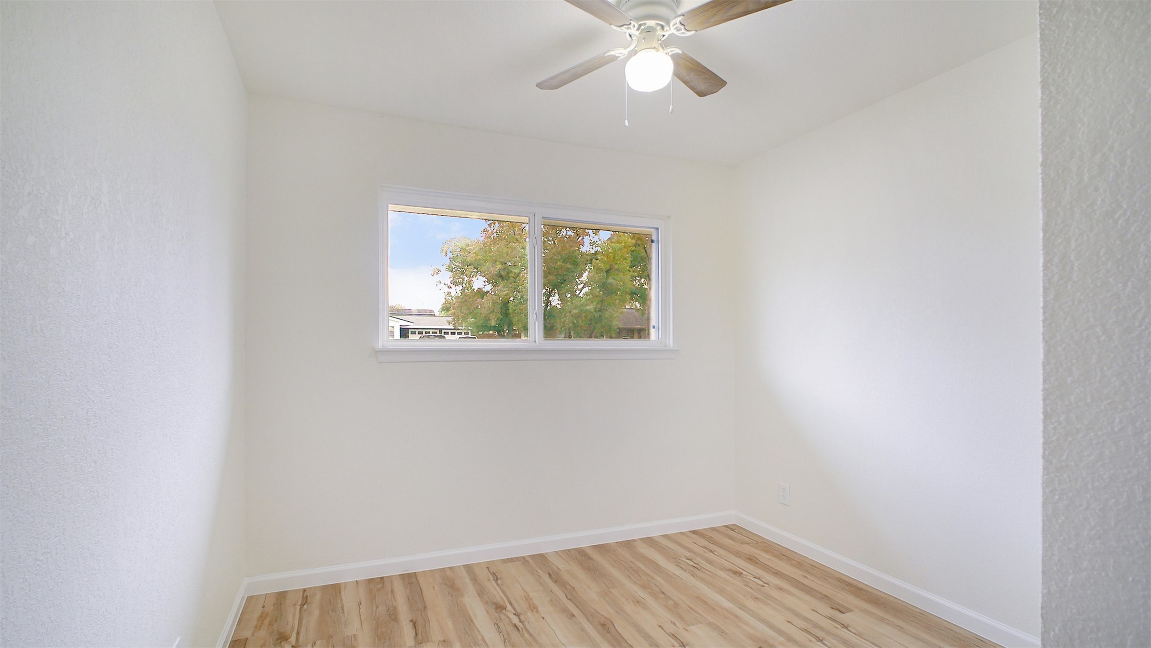 3513 Tanglebriar Drive Pasadena, TX 77503 - Photo 12 of 21 an empty room with wooden floor fan and windows