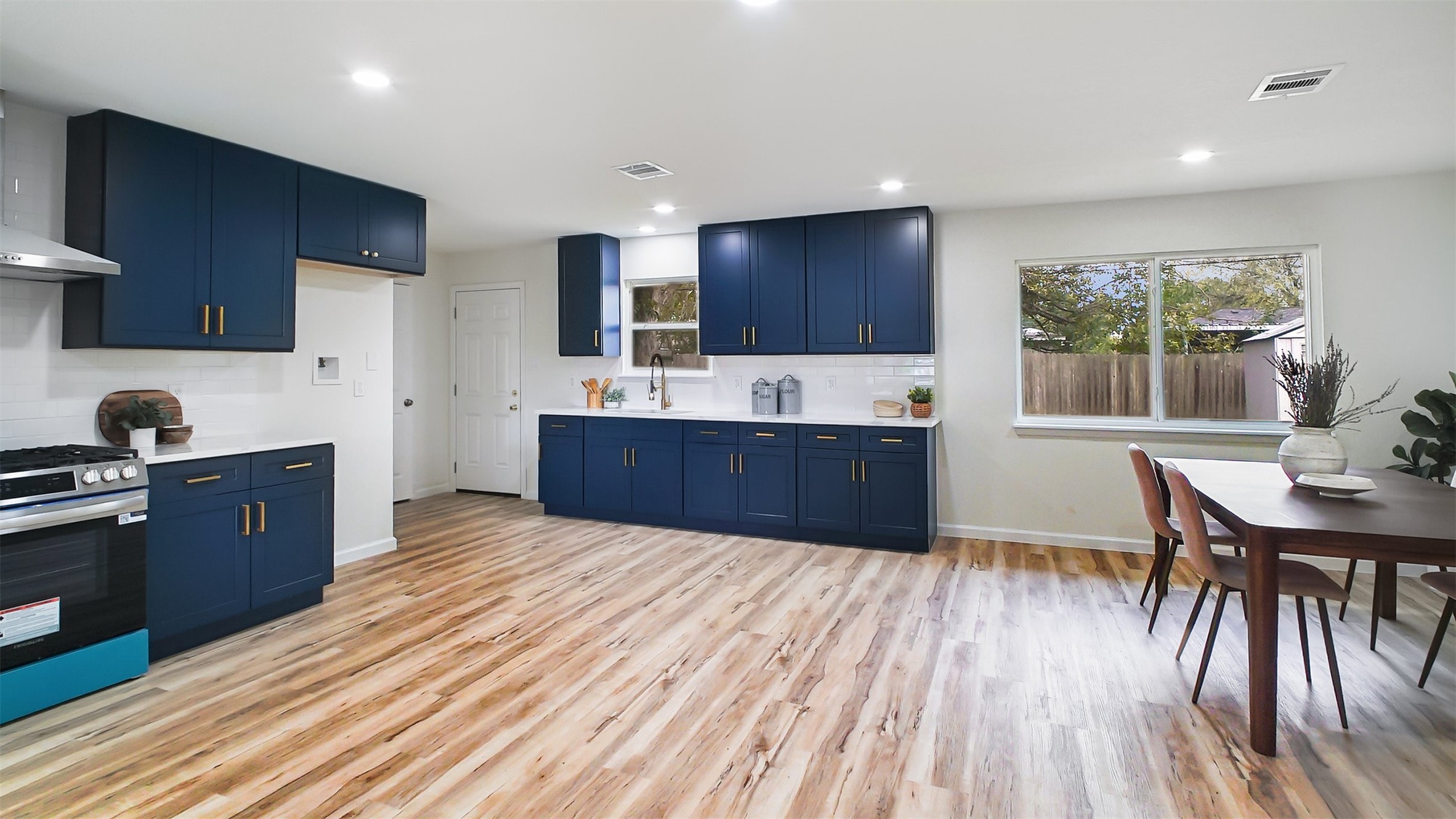 3513 Tanglebriar Drive Pasadena, TX 77503 - Photo 2 of 21 a large kitchen with wooden floor a sink dishwasher a dining table and chairs with wooden floor