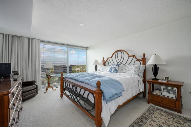 a bedroom with a bed and a flat tv screen on the dresser
