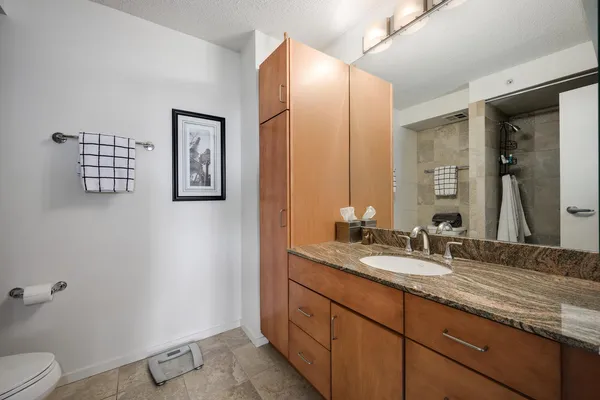 a bathroom with a granite countertop sink and a mirror