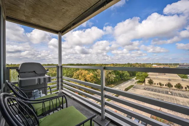 a view of a balcony with wooden floor and outdoor seating