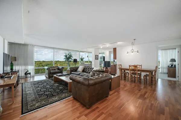 a living room with furniture wooden floor and a large window