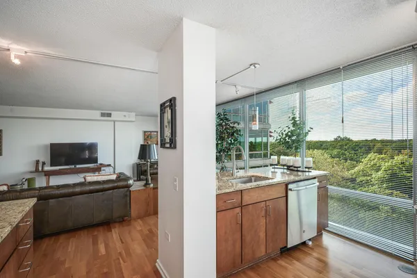 a kitchen with a sink appliances cabinets and wooden floor