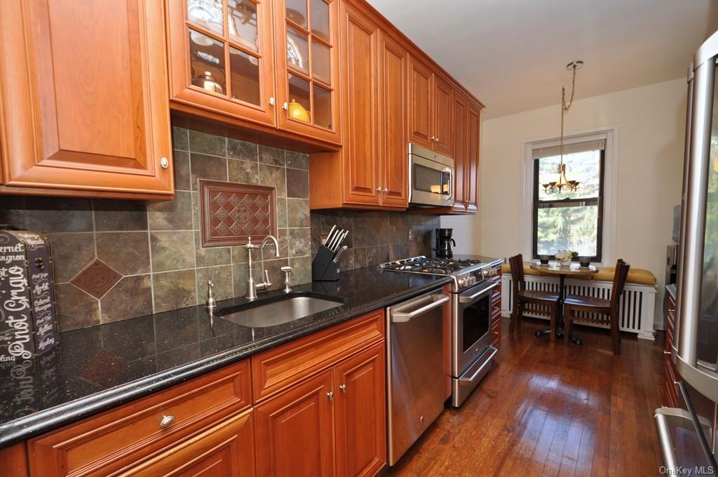 a kitchen with stainless steel appliances granite countertop a sink stove and wooden floor