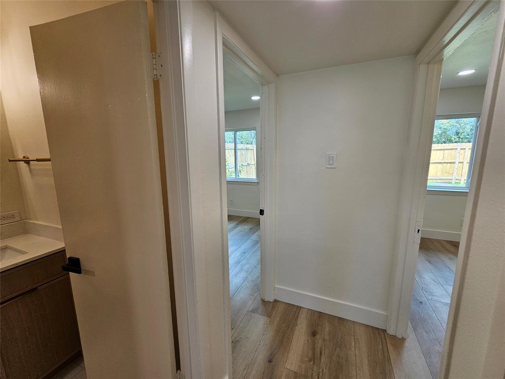 1725 R Avenue, Unit 1727 Plano, TX 75074 - Photo 9 of 20 Hallway featuring wood-finish flooring