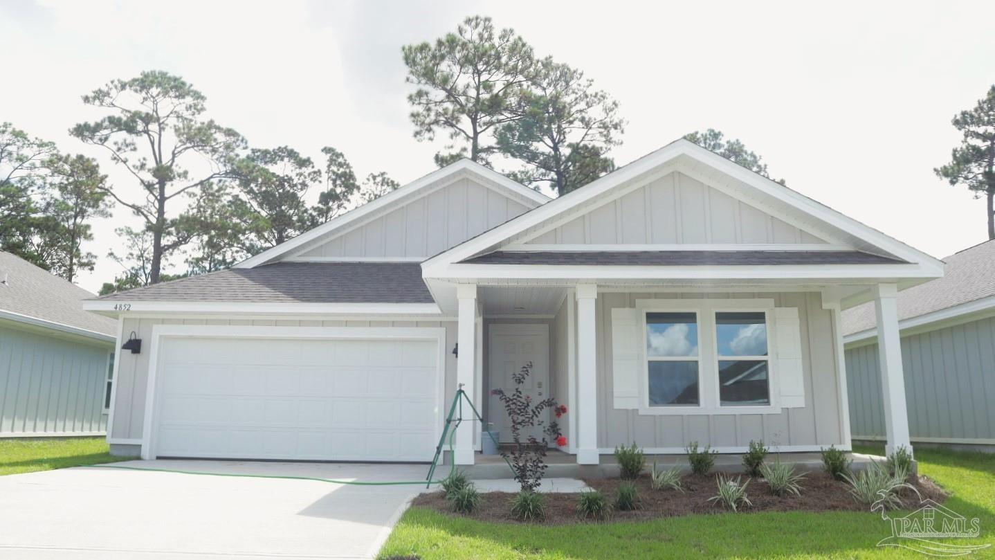 4852 Snipe Road Pace, FL 32571 - Photo 1 of 20 a front view of a house with a yard and garage