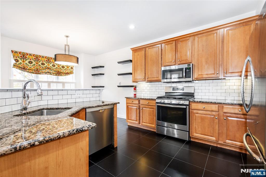 43 South Shore Drive, Unit 81 South Amboy, NJ 08879 - Photo 14 of 30 a kitchen with stainless steel appliances granite countertop a sink stove and microwave