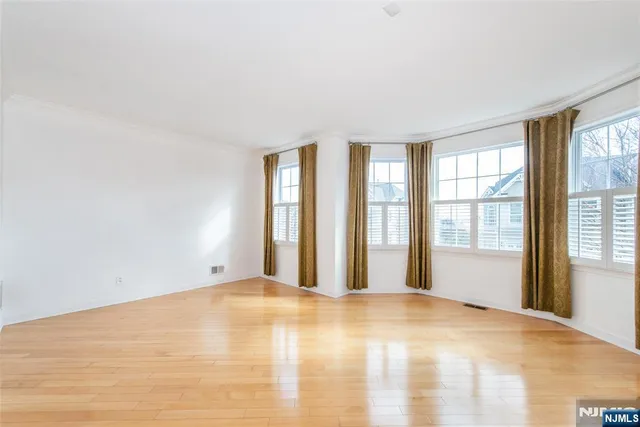 a view of empty room with wooden floor and fireplace