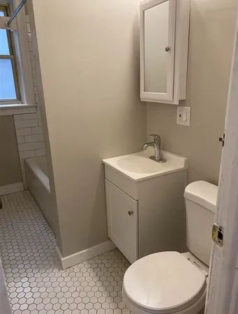 a bathroom with a toilet sink and mirror