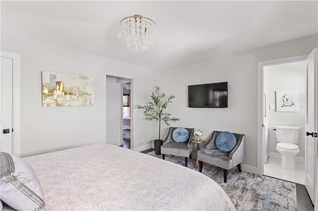 5925 Old Bill Cook Road Atlanta, GA 30349 - Photo 12 of 49 a bedroom with a bed and a chandelier