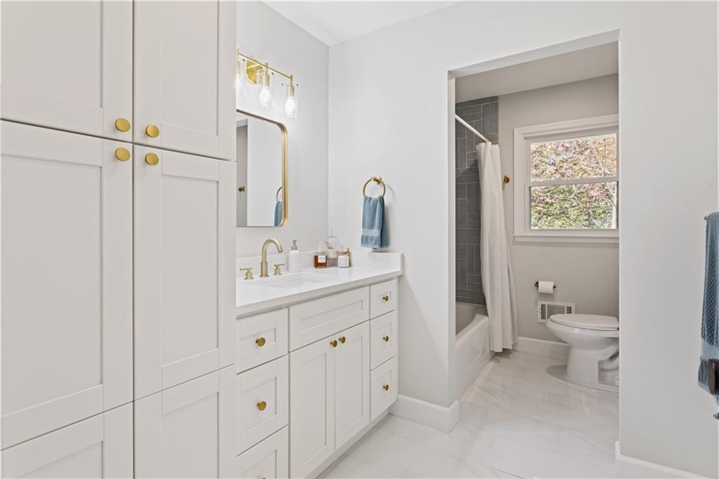 5925 Old Bill Cook Road Atlanta, GA 30349 - Photo 16 of 49 a bathroom with a toilet sink and mirror