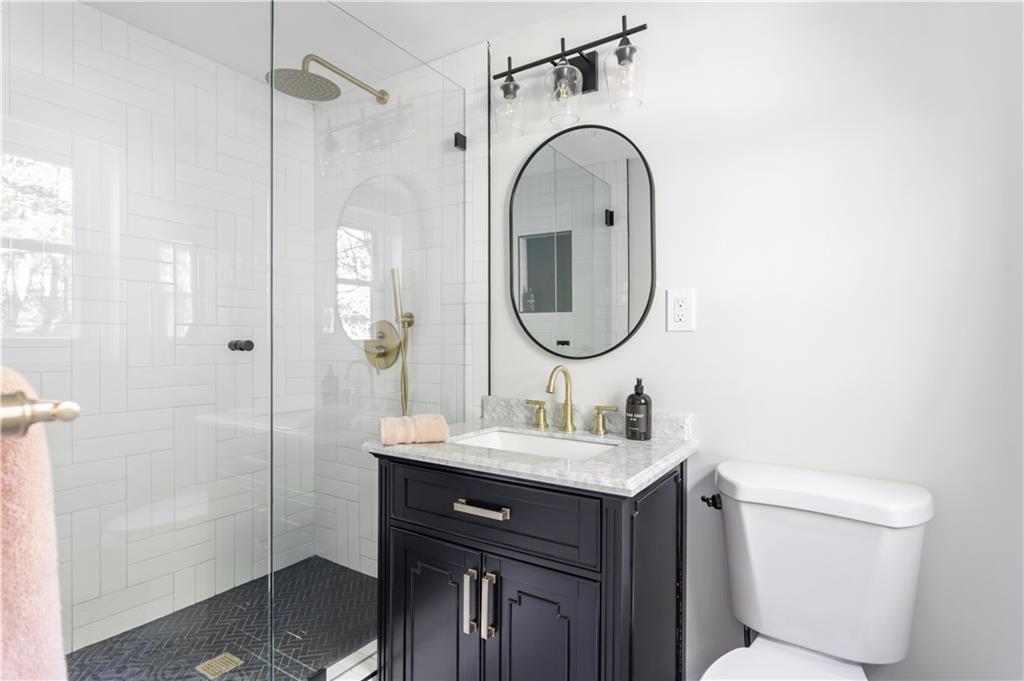 5925 Old Bill Cook Road Atlanta, GA 30349 - Photo 30 of 49 a bathroom with a sink a toilet and a mirror