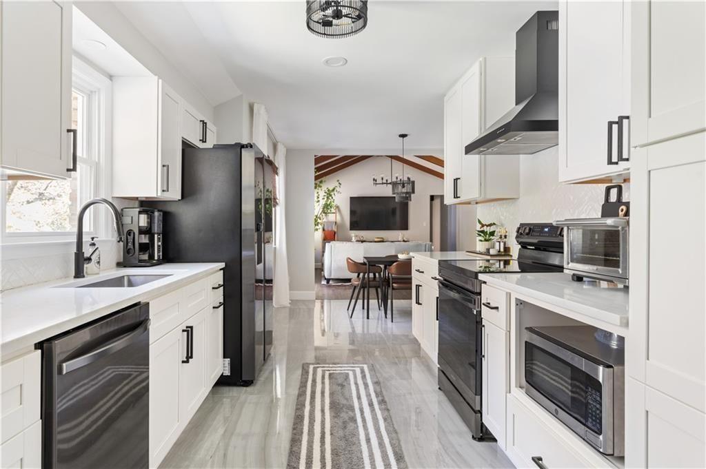 5925 Old Bill Cook Road Atlanta, GA 30349 - Photo 3 of 49 a kitchen with white cabinets and stainless steel appliances