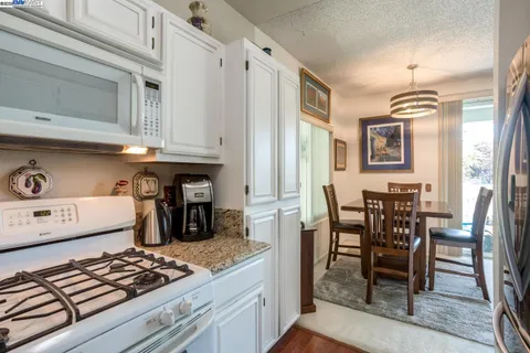 a kitchen with stainless steel appliances granite countertop a stove and a dining table