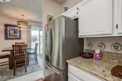 a kitchen with stainless steel appliances granite countertop a refrigerator and a stove