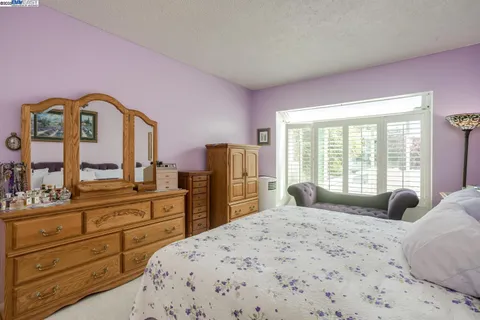 a bedroom with a bed and large windows